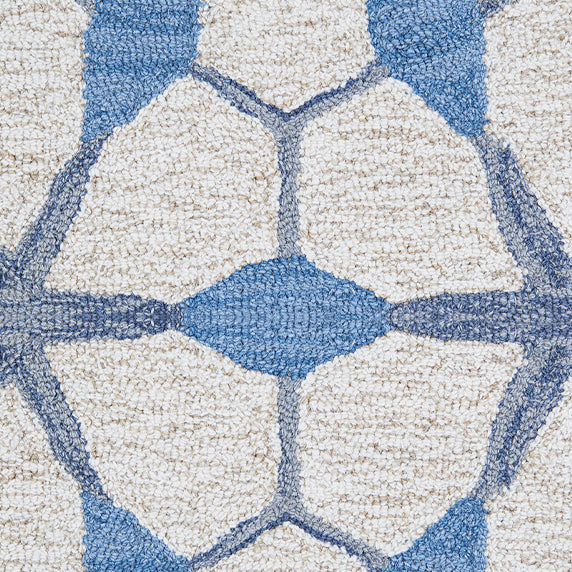 Detail of a wool broadloom carpet swatch in a geometric lattice pattern in shades of blue on a cream field.