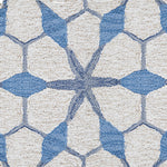 Wool broadloom carpet swatch in a geometric lattice pattern in shades of blue on a cream field.