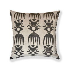 Square throw pillow in a repeating block-printed pattern of geometric tribal motifs in black on a light gray field.