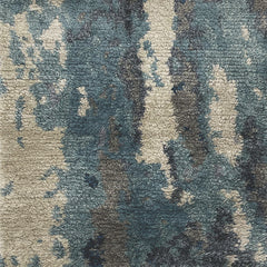 Woven high-pile rug swatch in an abstract watery print of shades of blue, gray and tan.