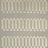Woven rug swatch with a repeating pattern of high-pile fringed stripes in cream on a gray field.