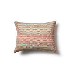 Rectangular throw pillow in a striped pattern of hand-drawn red and pink honeycomb shapes on a cream background.