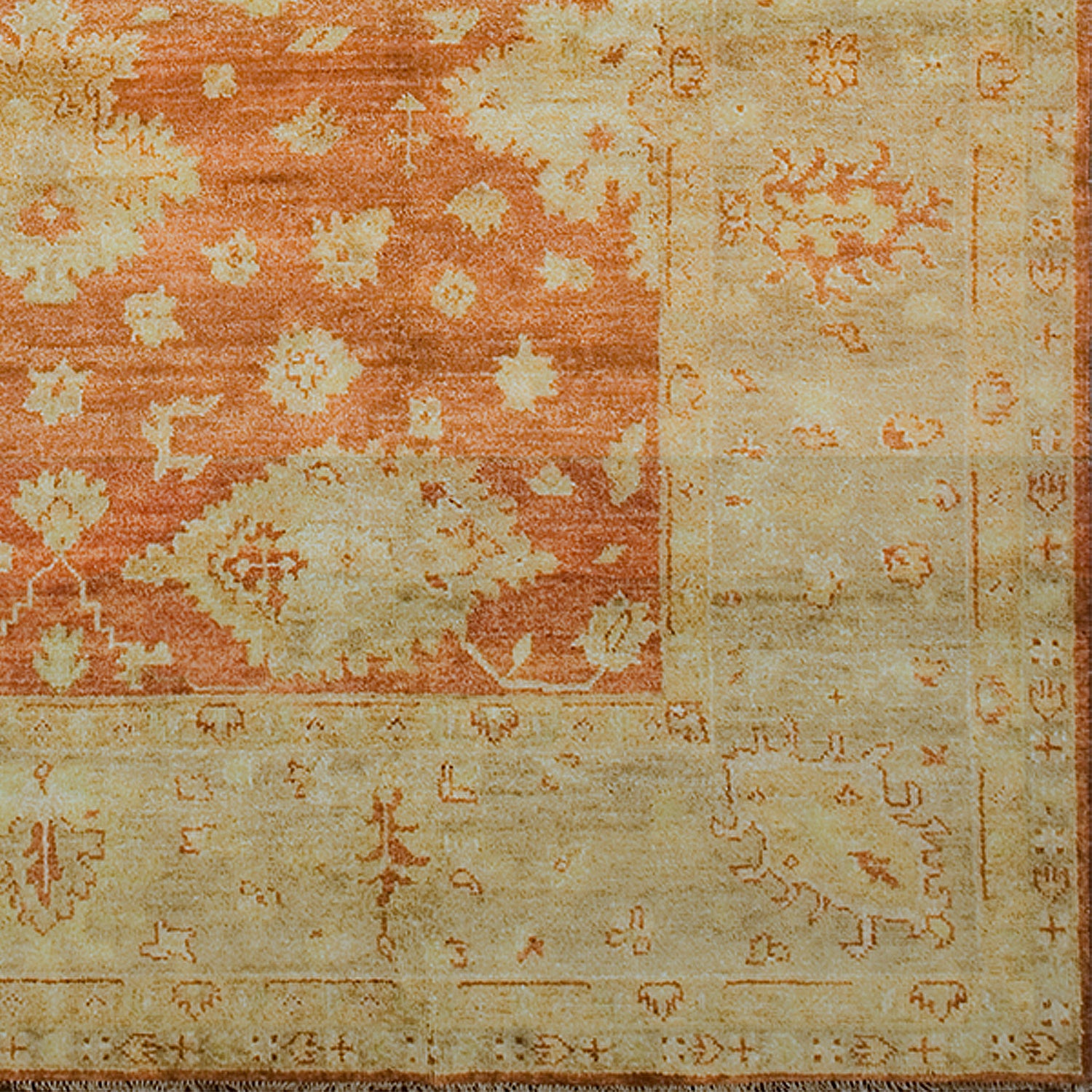 Woven rug swatch with a minimalist floral pattern in tan on a red field, with a tan border of linear florals in red.
