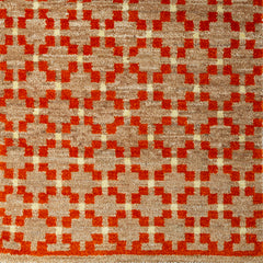 Woven rug swatch in a large-scale grid pattern featuring squares of red, tan and cream.