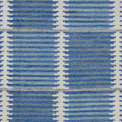 Woven rug swatch in a stripe motif broken by rows of rectangular shapes in white on a blue and green field.