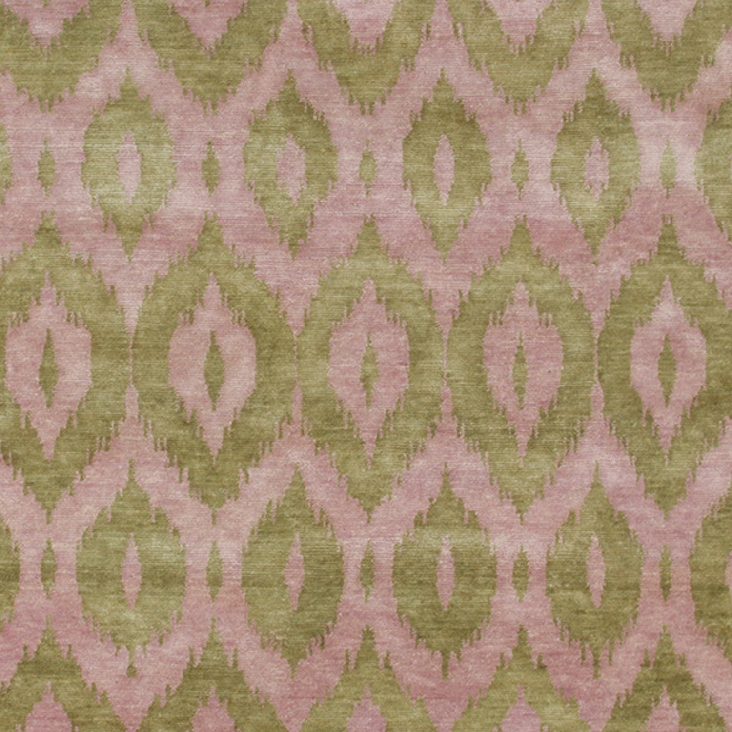 Detail of a woven rug with a green and mauve ikat diamond motif.