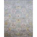 Large rectangular rug in an abstract floral pattern with a repeating floral border print in shades of pink, yellow and red on a mottled gray field.