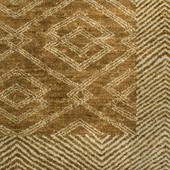 Detail of a woven high-pile rug in an interlocking diamond pattern with a dense stripe border. Pattern is white on a tan field.