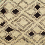 Woven high-pile rug swatch in a pattern of graduating diamond shapes in dark brown on a tan field.