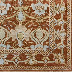 Woven rug swatch in a repeating floral pattern with a dense floral border in shades of light orange and tan on a red field.