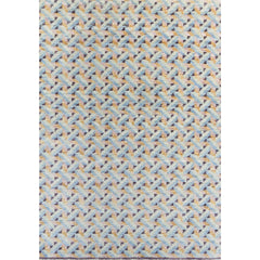 Rectangular rug in a dense interlocking prism pattern in shades of blue, pink, purple and gold