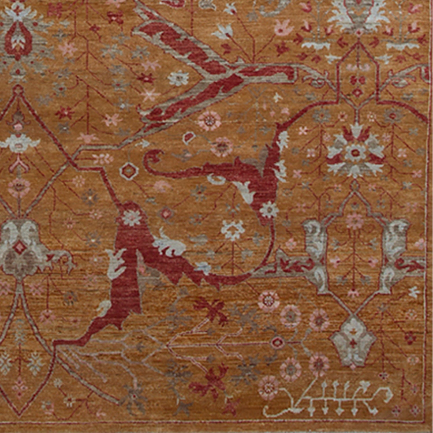 Woven rug swatch in a dense floral print in shades of red, pink and blue-gray on an orange field.