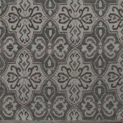 Woven rug swatch in a repeating floral paisley in shades of gray.
