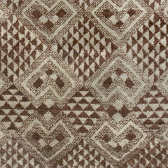 Woven high-pile rug swatch in a dense geometric pattern of diamonds in various sizes in shades of brown and cream.