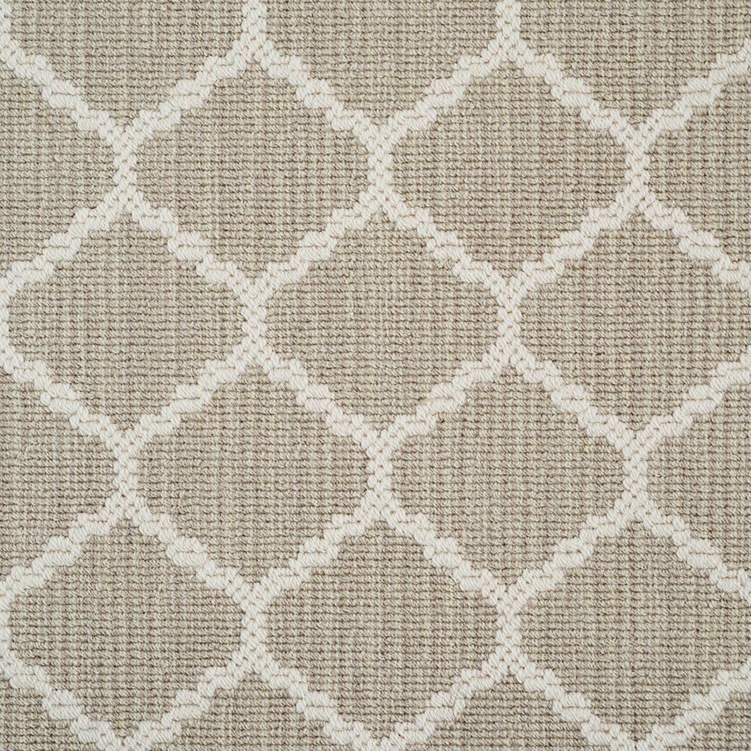 Wool-blend broadloom carpet swatch in a chunky lattice weave in cream on a mottled tan field.