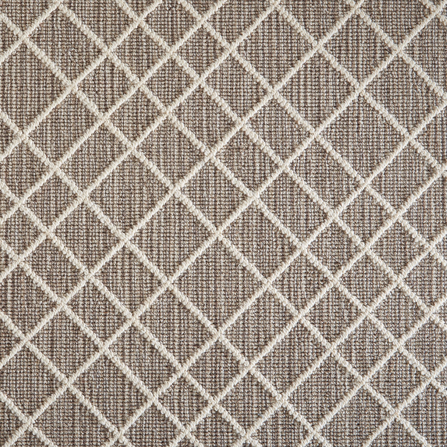 Wool-blend broadloom carpet swatch in a dimensional lattice print in cream on a mottled brown field.
