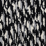 Wool-blend broadloom carpet swatch in a repeating abstract print in cream and silver on a black field.