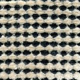 Wool-silk broadloom carpet swatch in a dimensional flat-and-tufted grid weave in cream and charcoal.