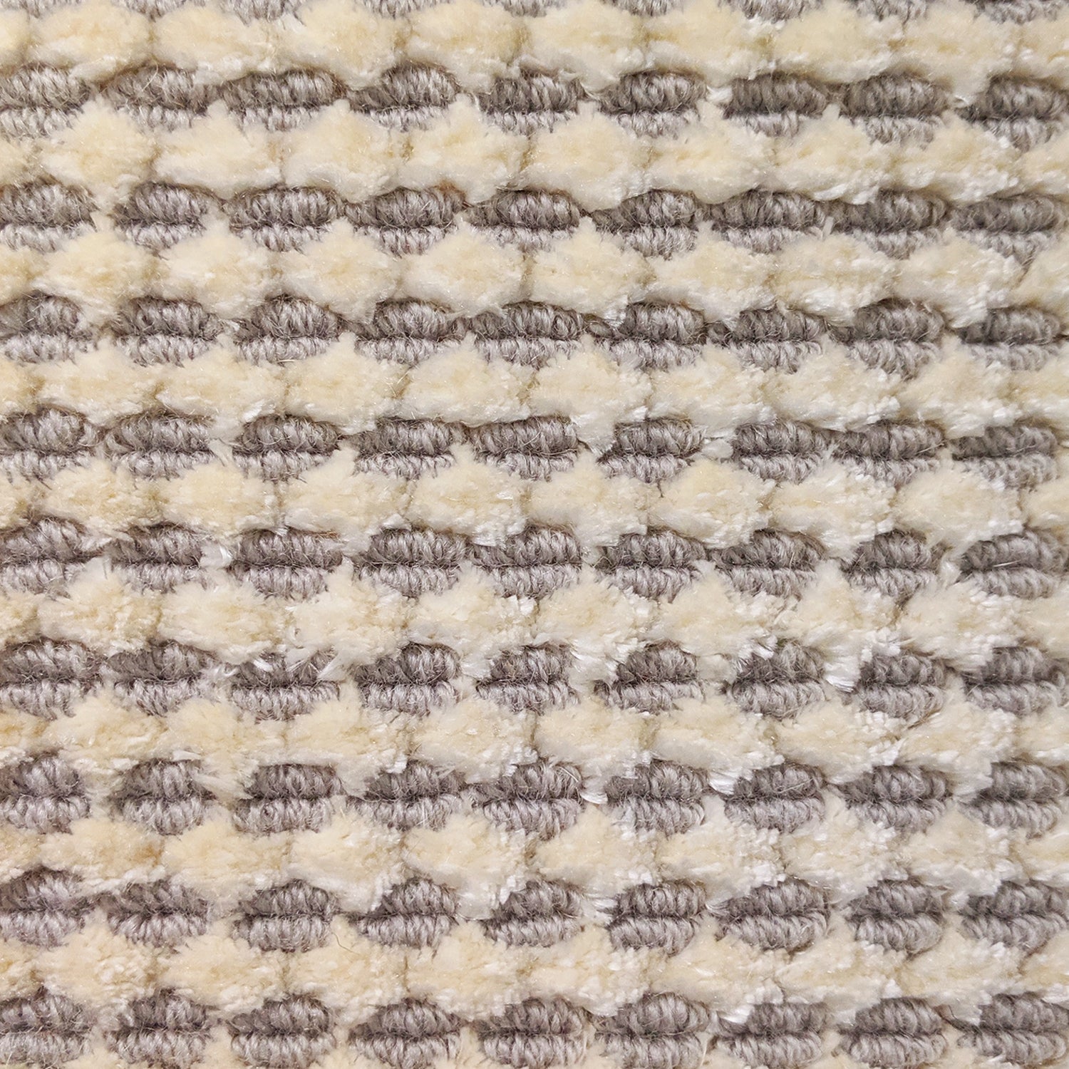 Wool-silk broadloom carpet swatch in a dimensional flat-and-tufted grid weave in cream and steel grey.