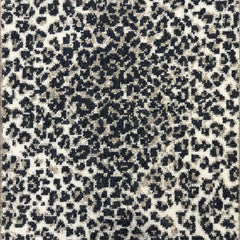 Wool broadloom carpet swatch in a cheetah print in black and tan on a cream field.