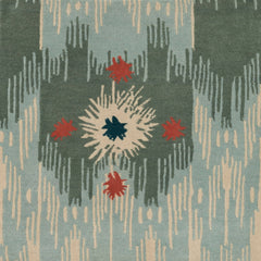 Detail of Estrella Rug in Lichen features a painterly abstract ikat in shades of cyan and seaglass blue and ecru with star shaped accents in coral and teal