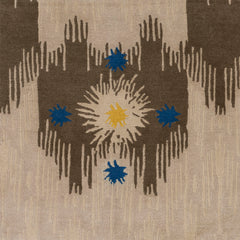 Detail of Estrella Rug in Quarry features a painterly abstract ikat in brown and taupe with star shaped accents in blue and yellow