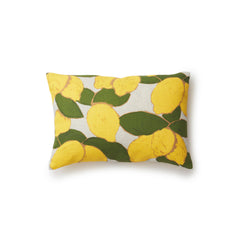 A rectangular throw pillow with a large-scale lemon and leaf print in yellow and green on a gray background.