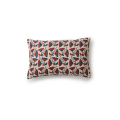 A rectangular throw pillow with a repeating pattern of large-scale graphic flowers in red and navy on a tan background.