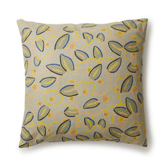 A square throw pillow in a large-scale minimal floral print in shades of yellow, peach and green on a light blue background.