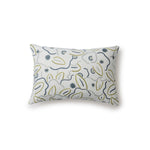 A rectangular throw pillow in a large-scale minimal floral print in shades of blue, green and gray on a light blue background.