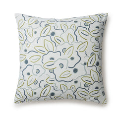 A square throw pillow in a large-scale minimal floral print in shades of blue, green and gray on a light blue background.