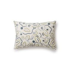 A rectangular throw pillow in a large-scale minimal floral print in shades of blue, green and gray on a tan background.