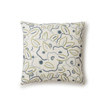 A square throw pillow in a large-scale minimal floral print in shades of blue, green and gray on a tan background.