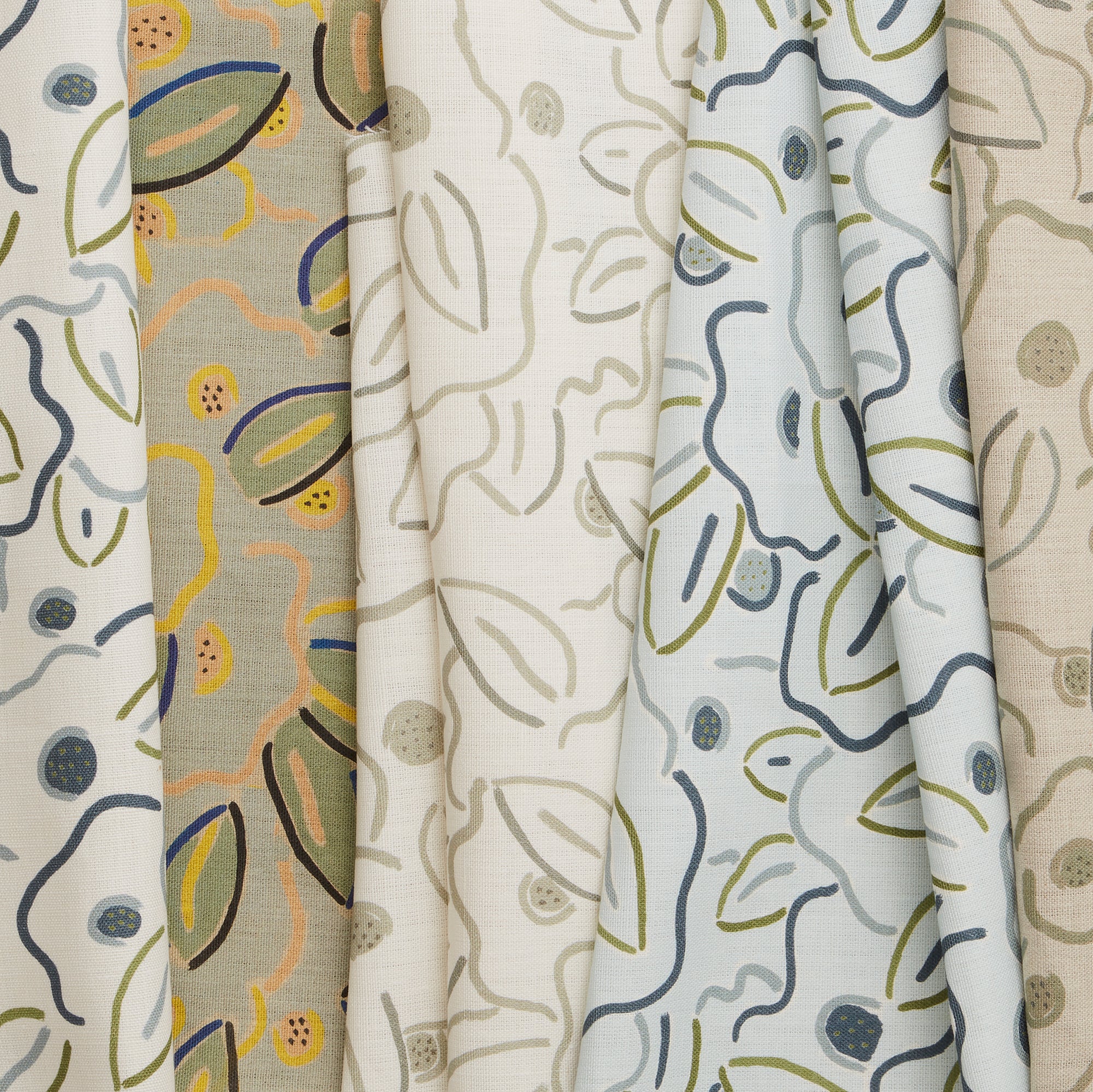 A row of fabric swatches, all in the same large-scale minimal floral print in different colorways with tan, cream and white fields.