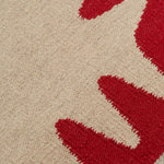Detail of the Waver Rug in Pillbox Red, a solid Ivory field with a red flame stitch border. 