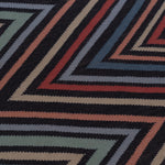 Detail of To The Point Rug in Hessonite-Garnet-Slate, a zig zag pattern in red, blue coral with black. 