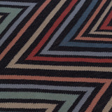 Detail of To The Point Rug in Hessonite-Garnet-Slate, a zig zag pattern in red, blue coral with black. 