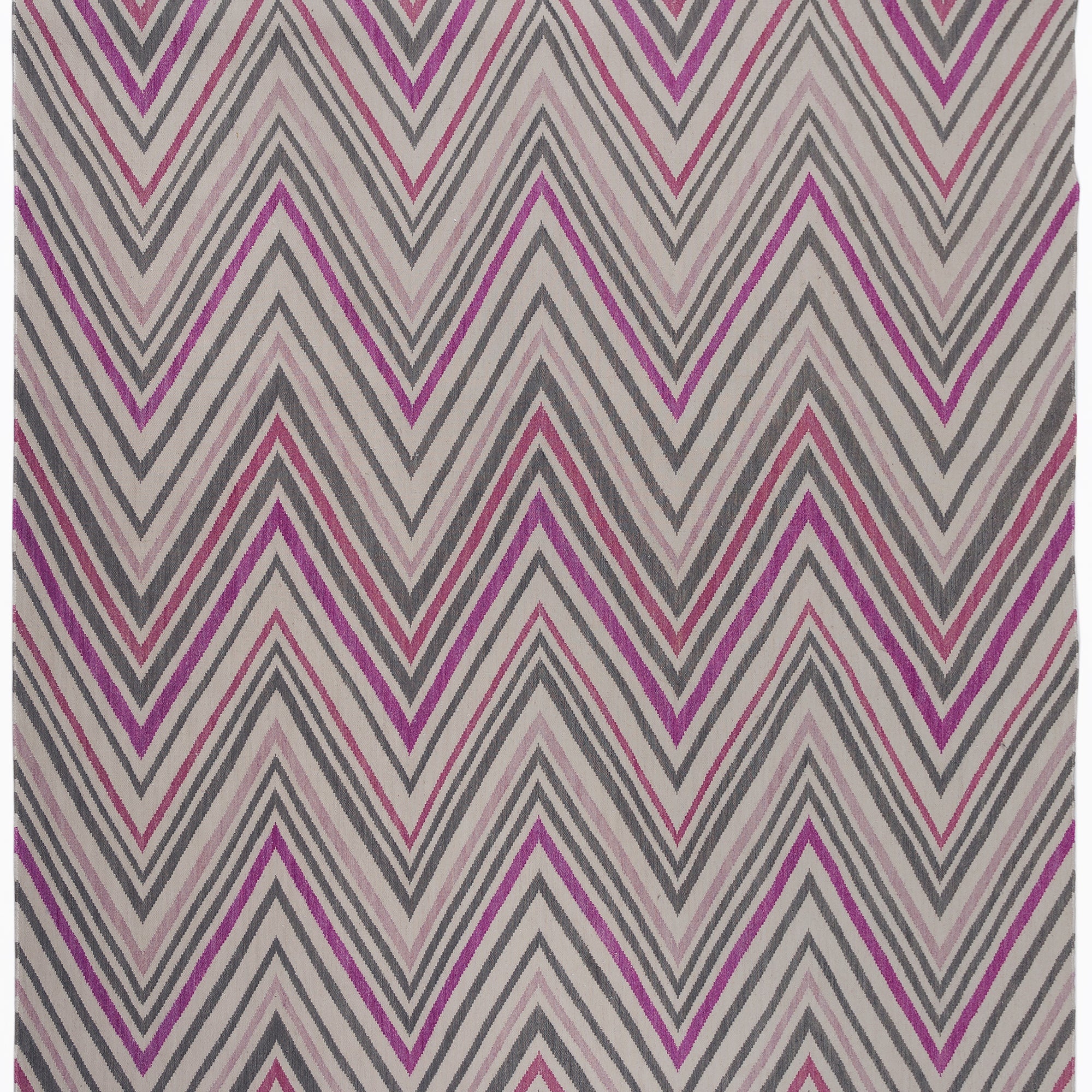 Zig Zag Rug in Ruby-Rose, a mutli color zig zag pattern in fucshia, magenta, link and charcoal on a white field with a tassled edge. 