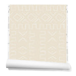 A partially unrolled roll of wallpaper in a minimalist African-inspired line design of painted white on a beige background.