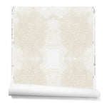 Partially unrolled wallpaper in a dense hand-drawn symmetrical pattern in shades of beige on a white background.
