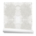Partially unrolled wallpaper in a dense hand-drawn symmetrical pattern in shades of gray on a white background.