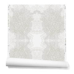 Partially unrolled wallpaper in a dense hand-drawn symmetrical pattern in shades of gray on a white background.