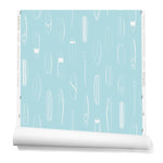 A roll of wallpaper with a pattern of illustrated surfboards in white on a light blue background.