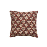 A square throw pillow with a repeating Moroccan-inspired scallop pattern in white and red on a maroon background.