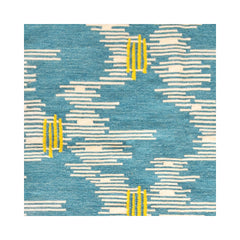 Detail of a woven rug in an undulating stripe pattern in cream with yellow accents, on a bright blue field.