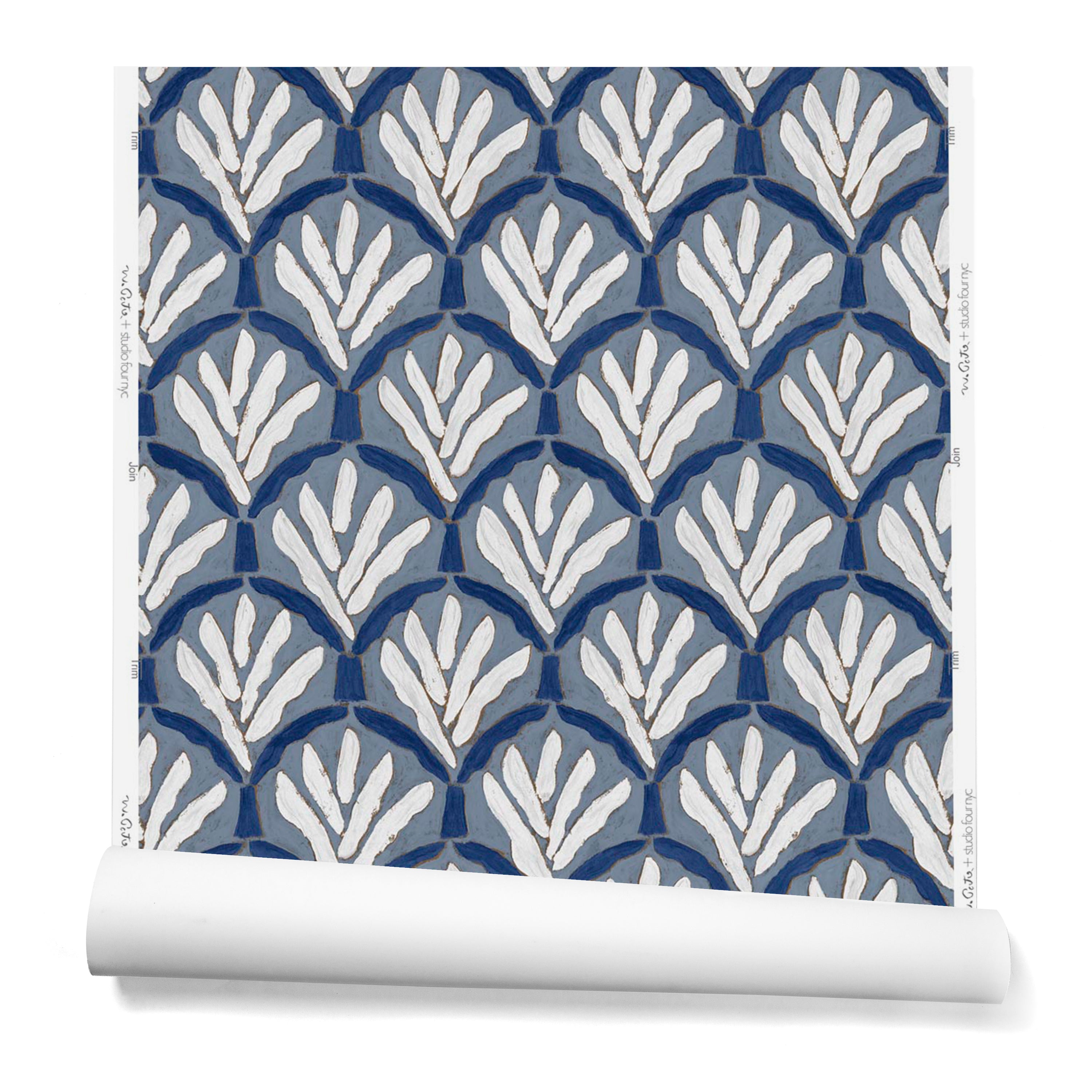 A hanging roll of wallpaper with a repeating Moroccan-inspired scallop pattern in navy and white on a blue background.