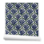 A hanging roll of wallpaper with a repeating Moroccan-inspired scallop pattern in navy and green on a white background.
