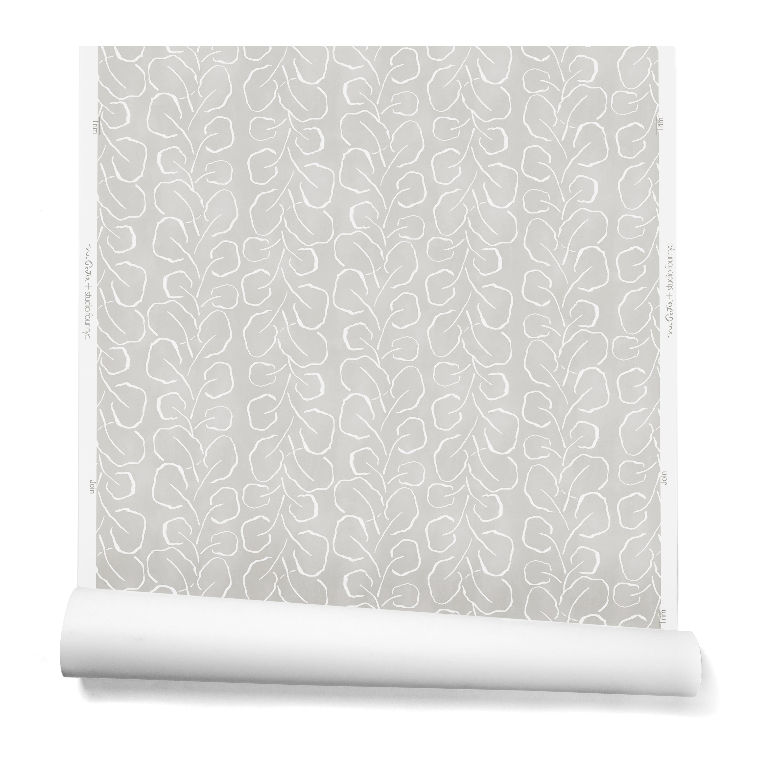 A hanging roll of wallpaper with a large-scale repeating leaf print in white on a light gray watercolor background.