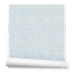 A hanging roll of wallpaper with a large-scale repeating leaf print in white on a light blue watercolor background.