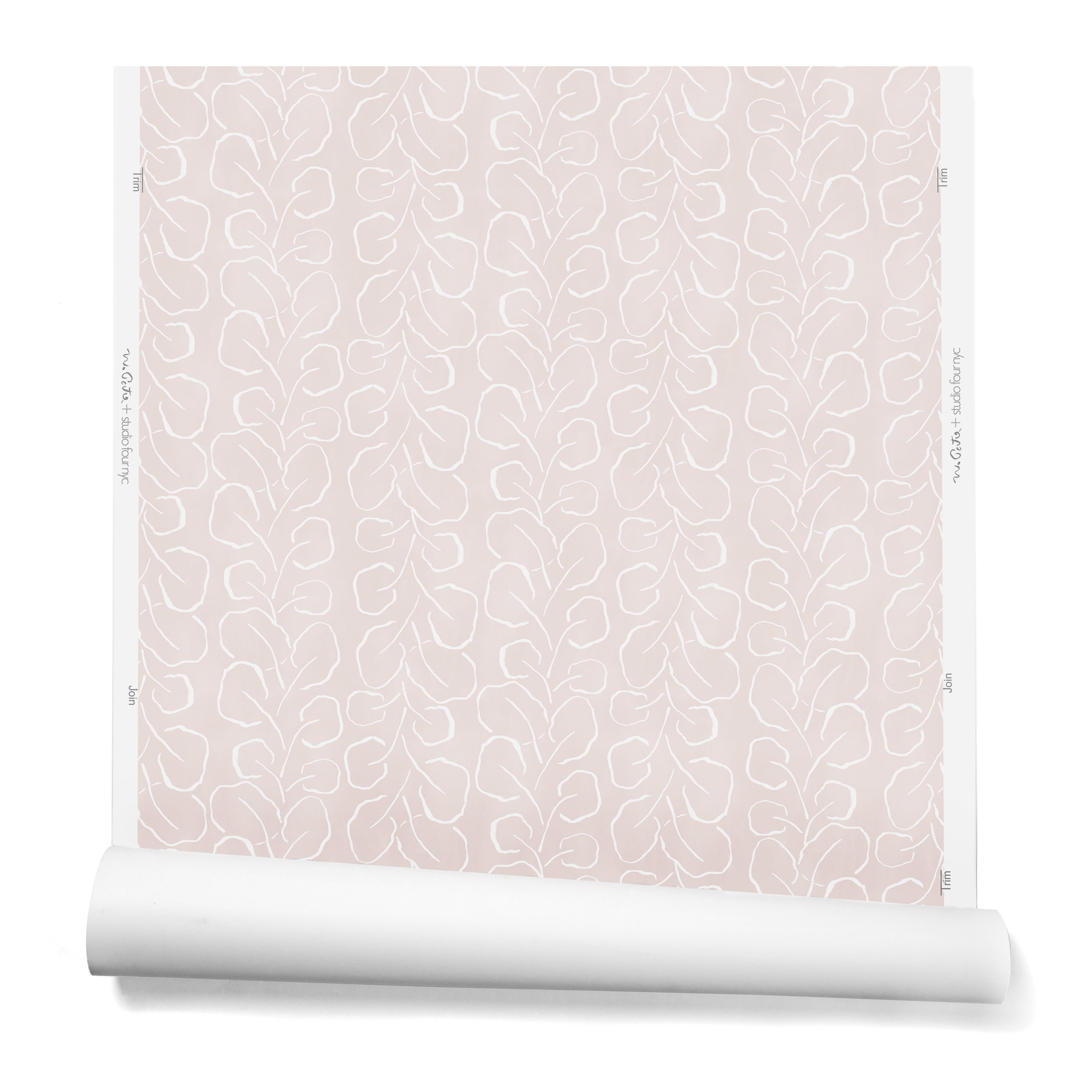 A hanging roll of wallpaper with a large-scale repeating leaf print in white on a light pink watercolor background.